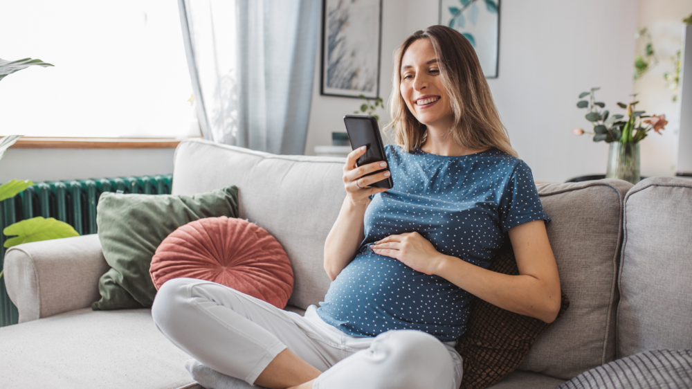 Pregnant woman using phone to connect with her partner