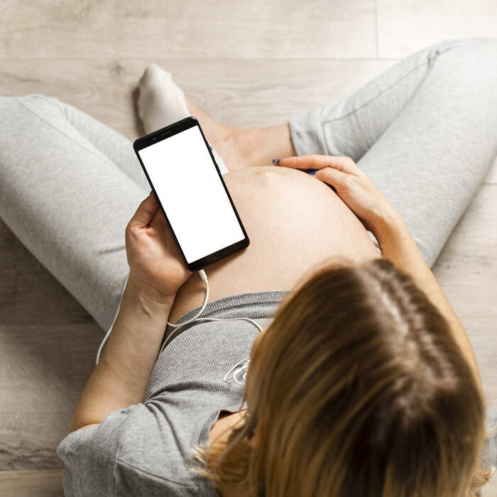 top-view-pregnant-woman-holding-phone