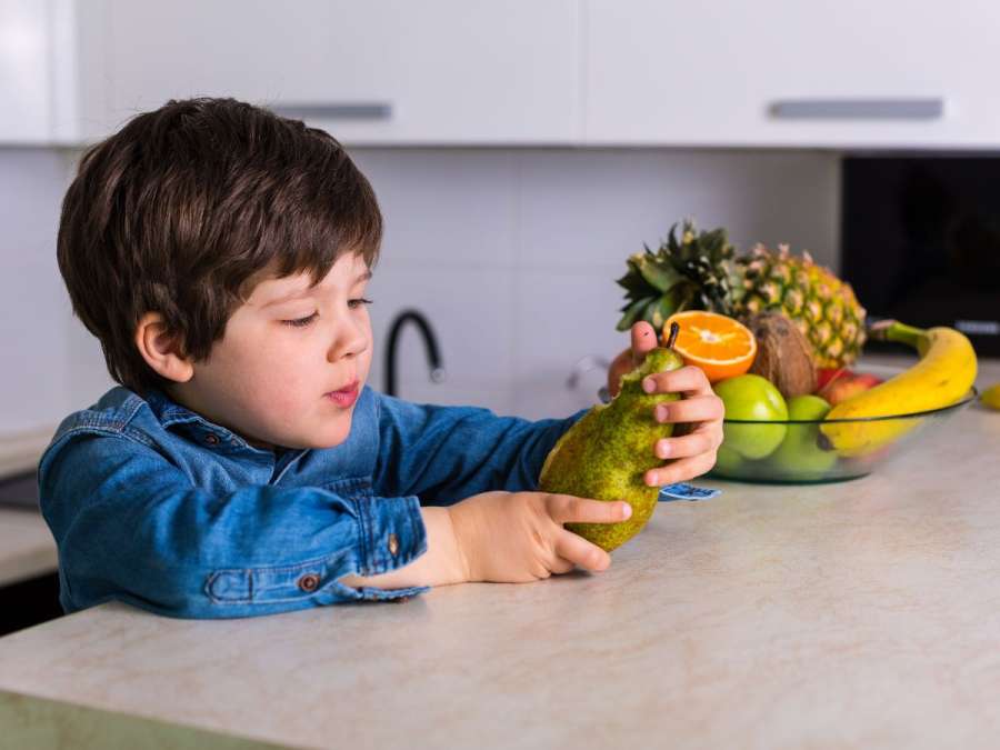 CHILD HOLDING A FRUIT