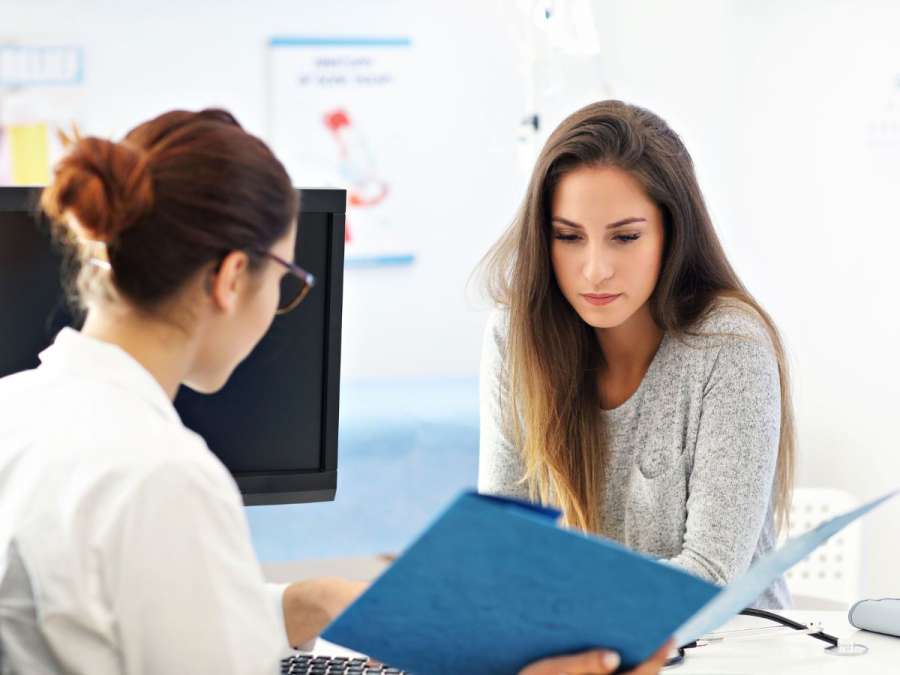 STRESSED WOMAN TALKING TO DOCTOR