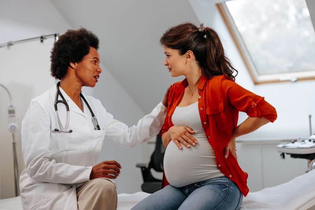 pregnant woman discussing birth plan with doctor