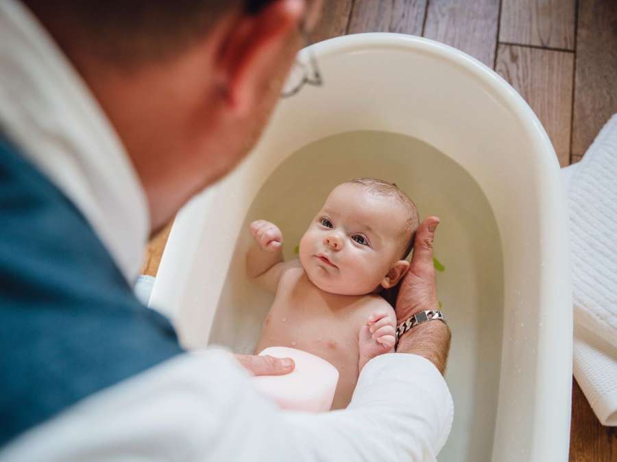 Father giving a bath to baby