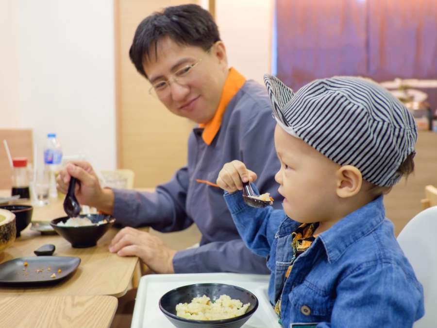 CHILD EATING with family