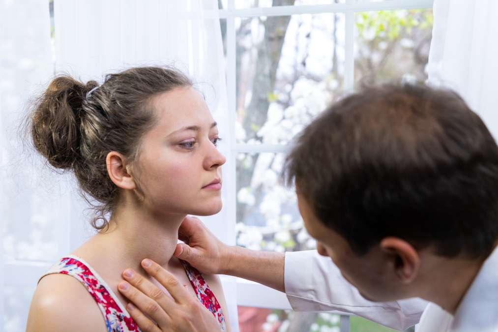Doctor checking thyroid- Risk Factors for Postpartum Depression
