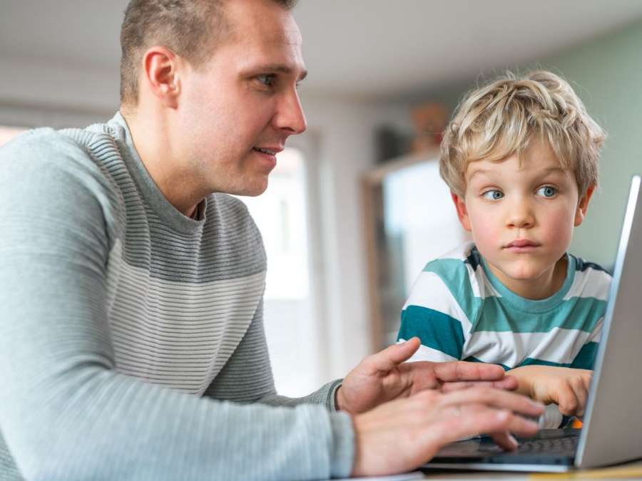 father working and son watching- Children's Digital Literacy