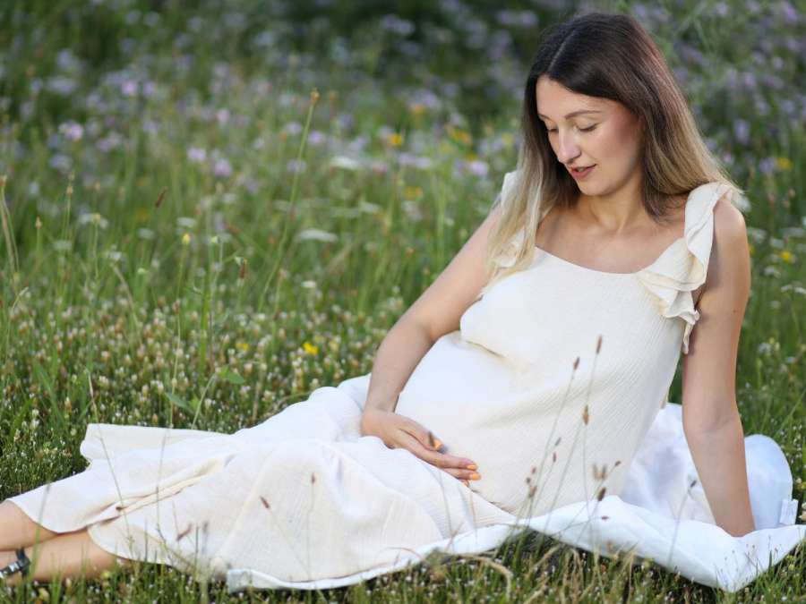 pregnant woman sitting in a beautiful maternity gown