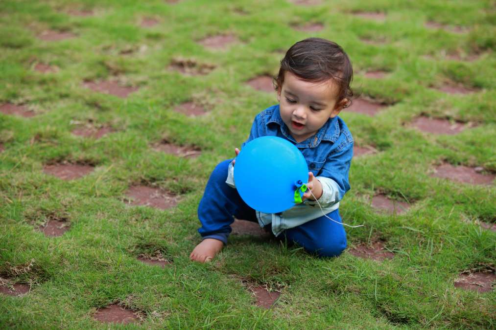 Toddler plays with a balloon in the outdoor