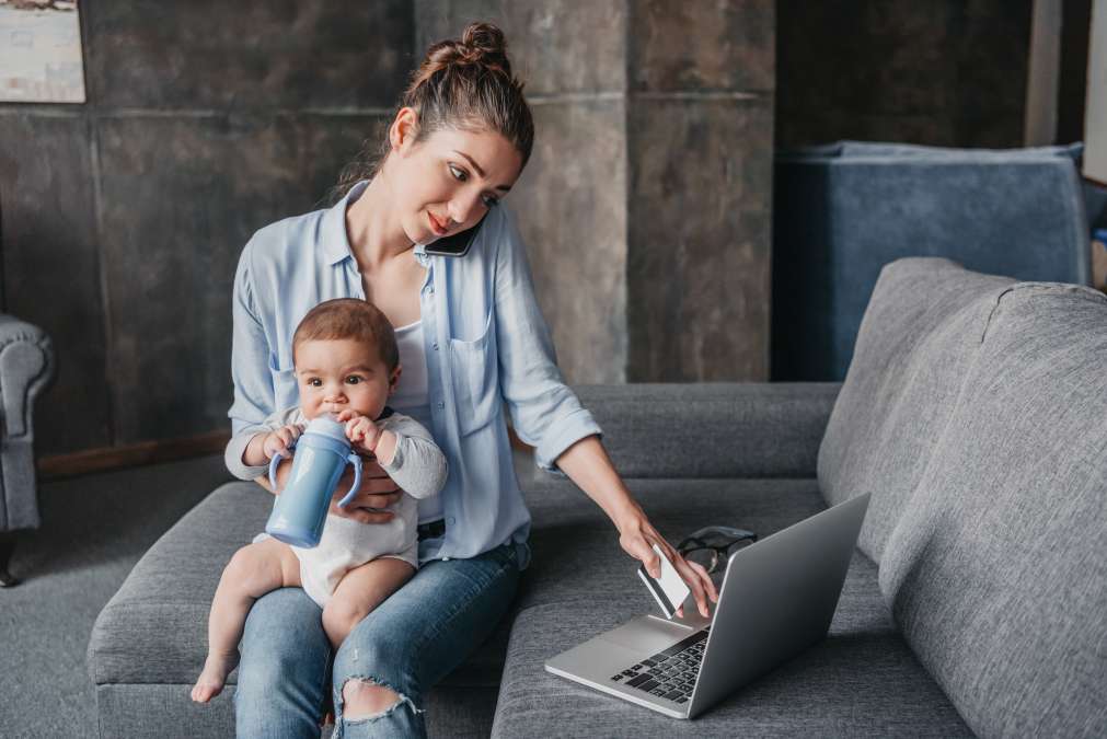 mother with baby boy remote working and using laptop