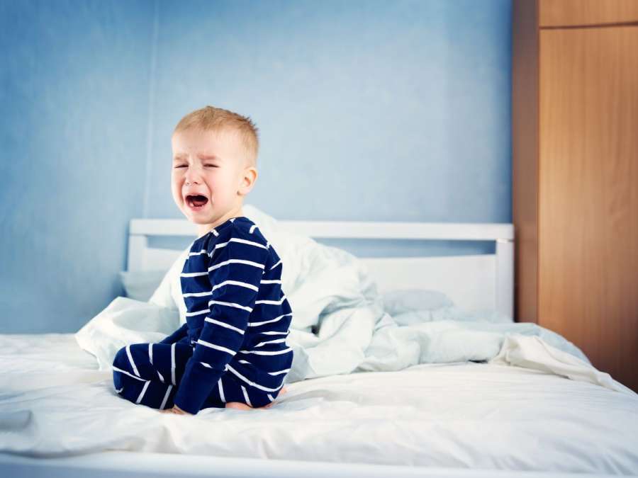 child crying in bed-  Sleep Challenges In Toddlers