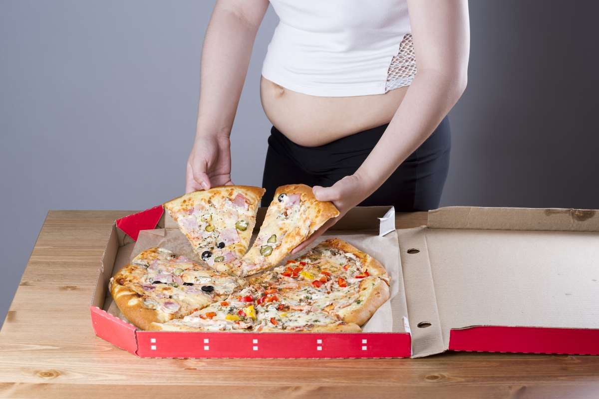 Obese woman with pizza in hand