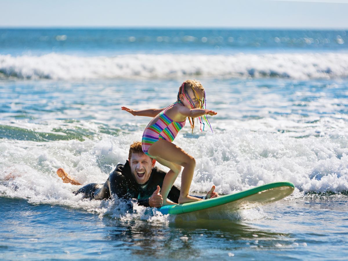 child and father surfng