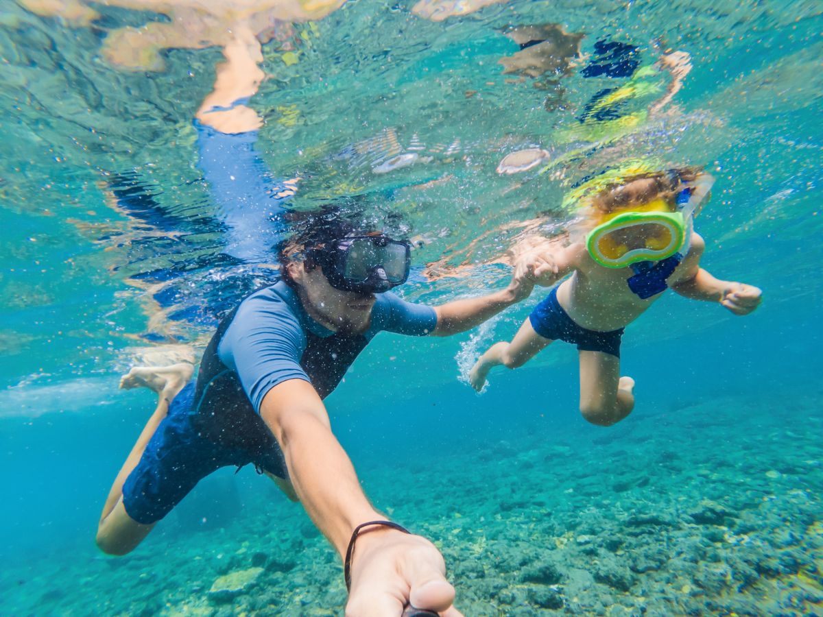 child and father snorkeling