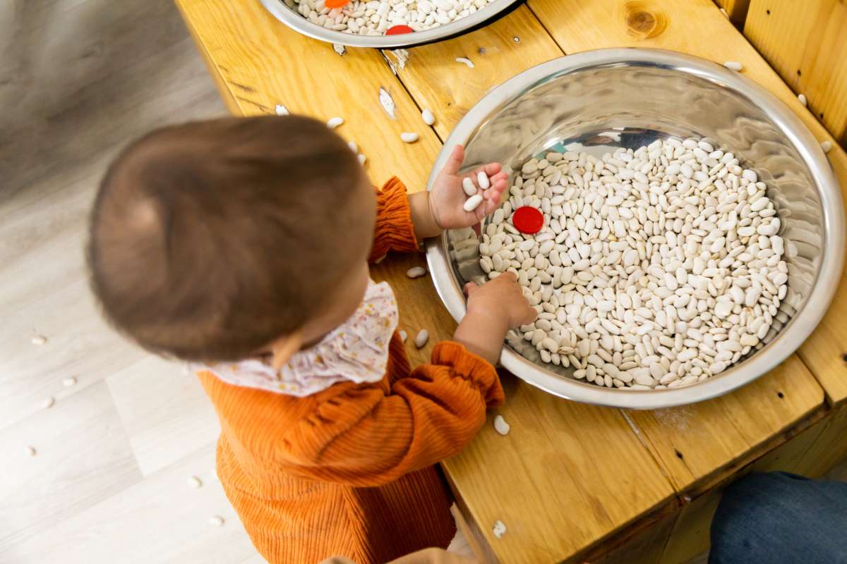 toddler playing with grains
