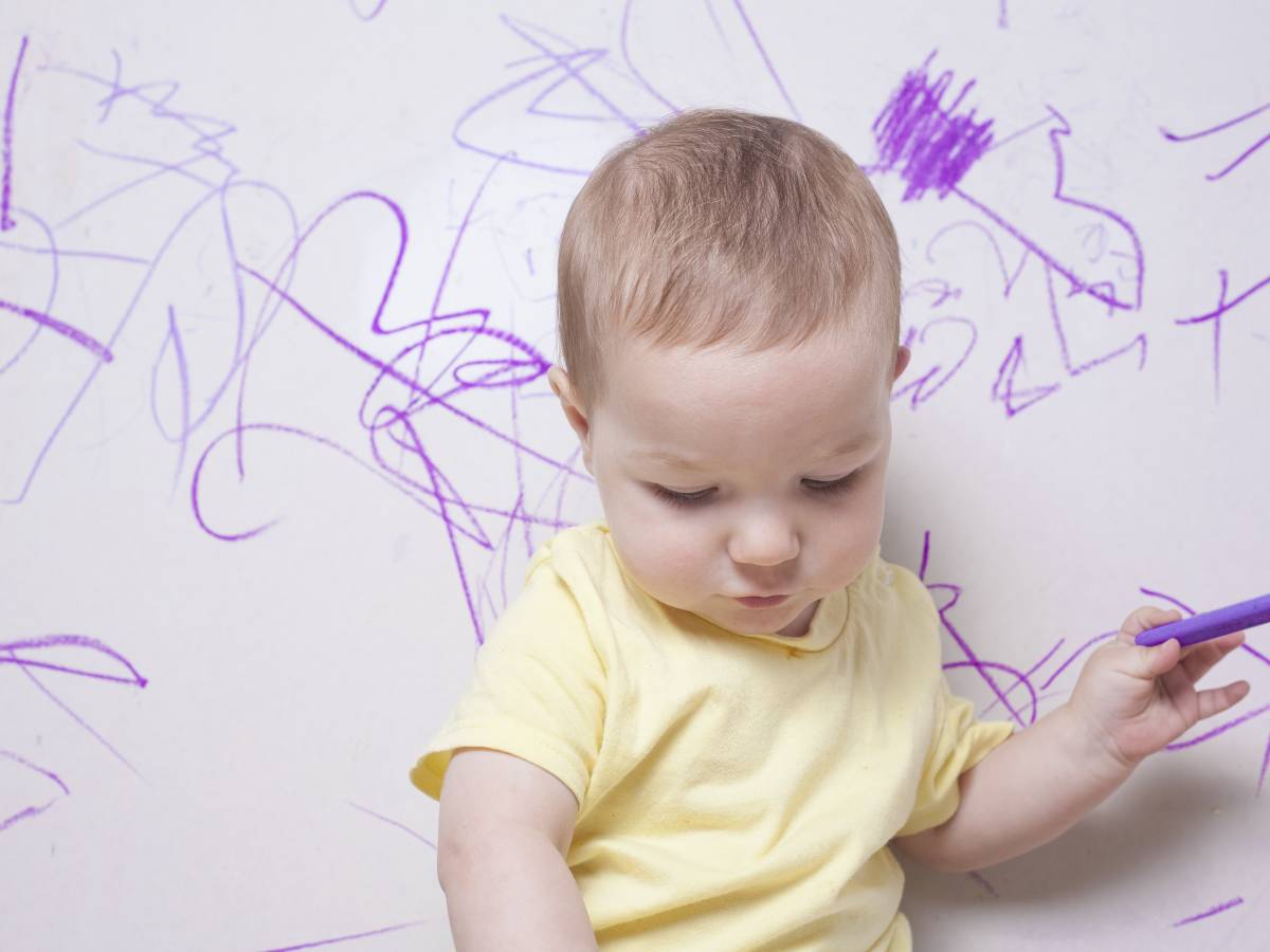 child writing on wall