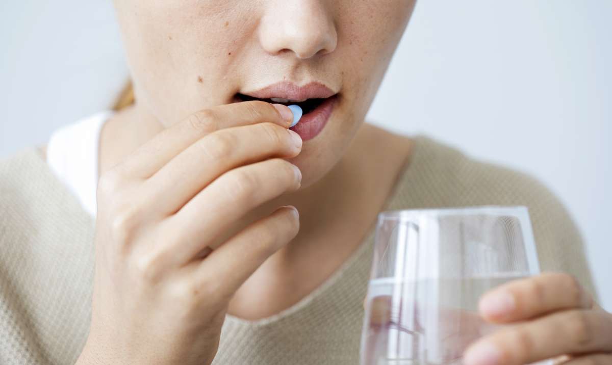 Young woman taking a pill- Medications for PCOD and PCOS
