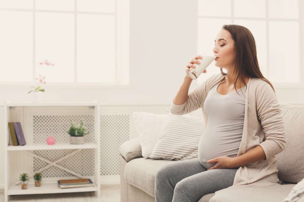 Pregnant woman drinking glass of milk- Benefits Of Calcium In Pregnancy