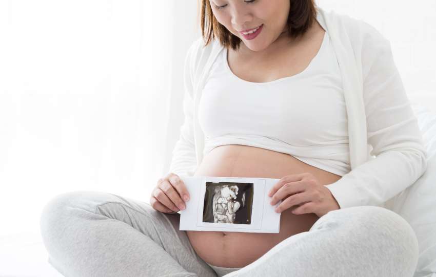 Pregnant women holding four-dimensional ultrasound images on hand, Techniques and abdominal applications, Prenatal diagnosis concept, Asian pregnancy woman model
