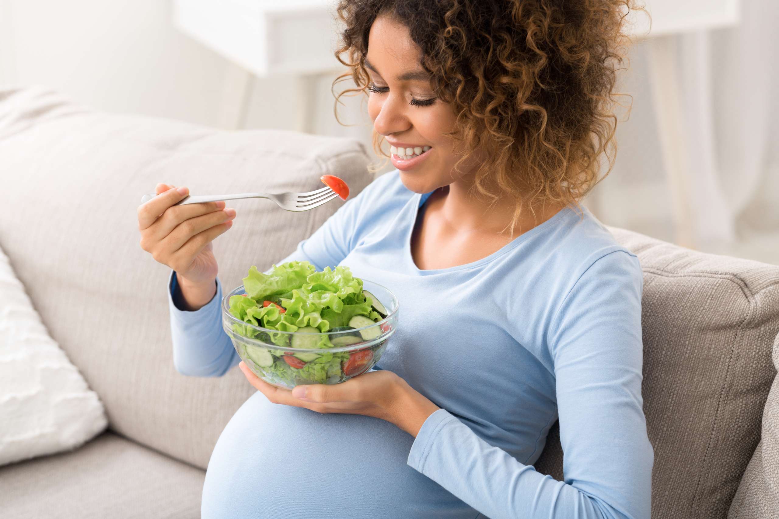 Healthy pregnancy food. African-american girl eating fresh vegetable salad-  Iodine In Your Diet 