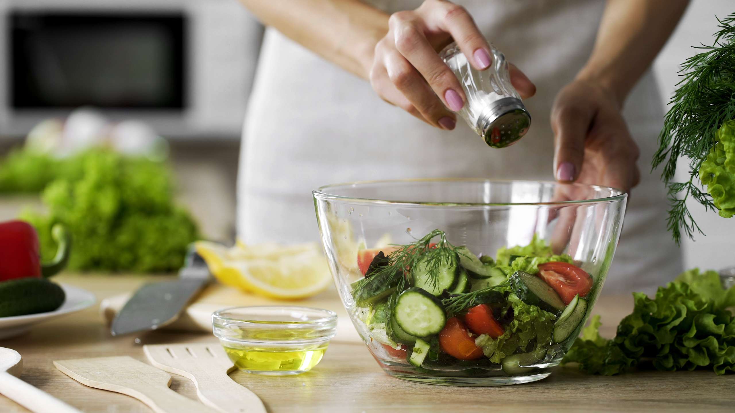Woman adding salt in vegetable salad glass bowl, health care, excessive salting- Zinc In Pre-Pregnancy Nutrition