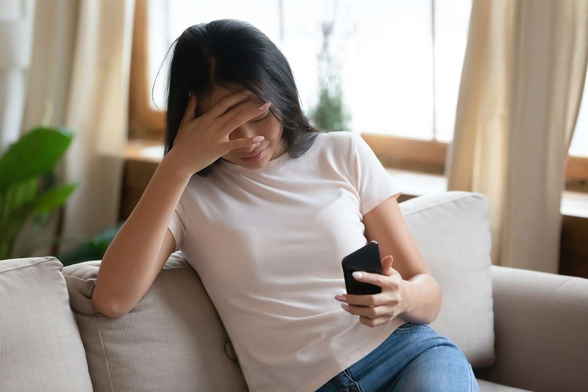Asian woman holds smartphone read unpleasant message feels desperate- Effects Of Social Media On Emotions