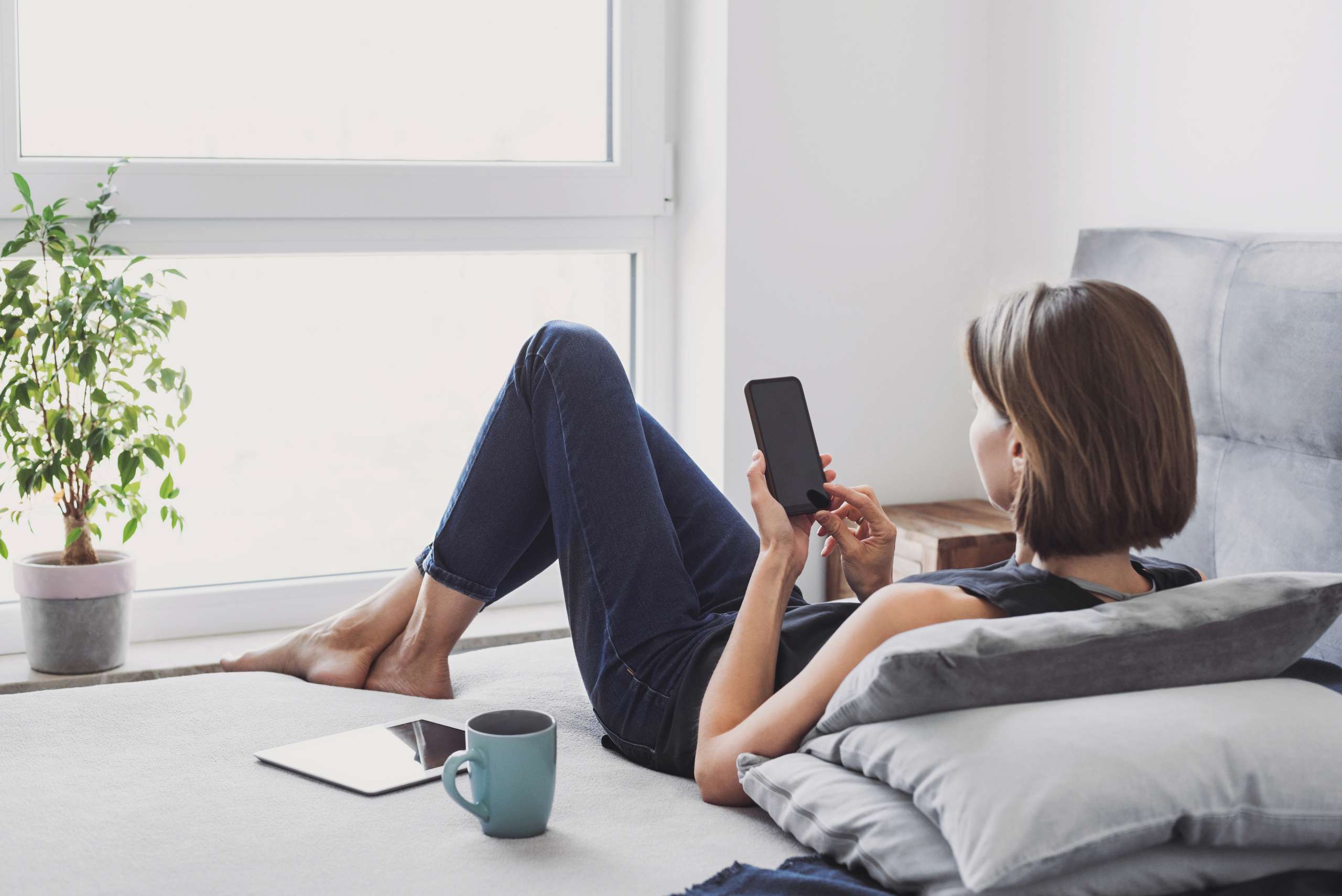 Woman resting at home and using smartphone- Fertility And Online Forums