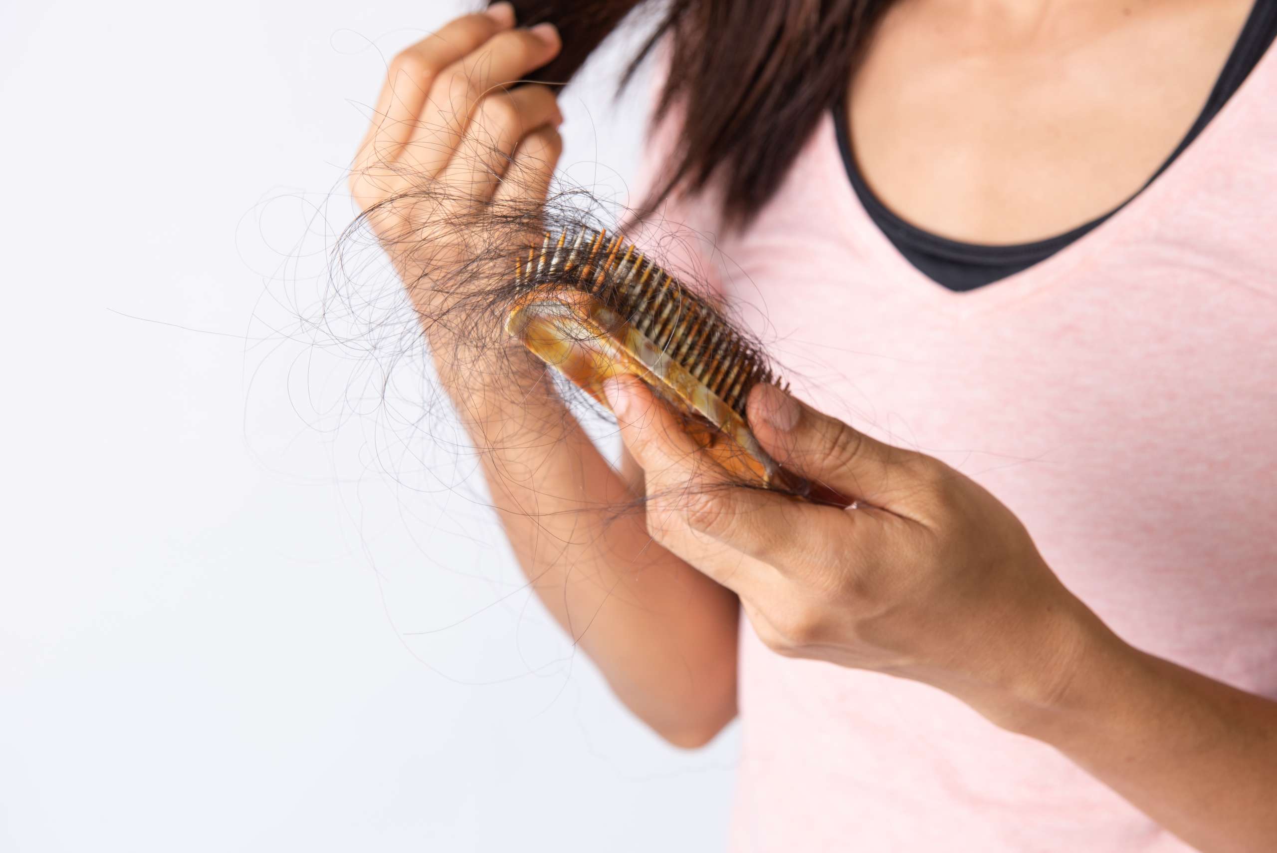 Woman hand hoding hairs fall in comb, hair fall everyday serious problem
