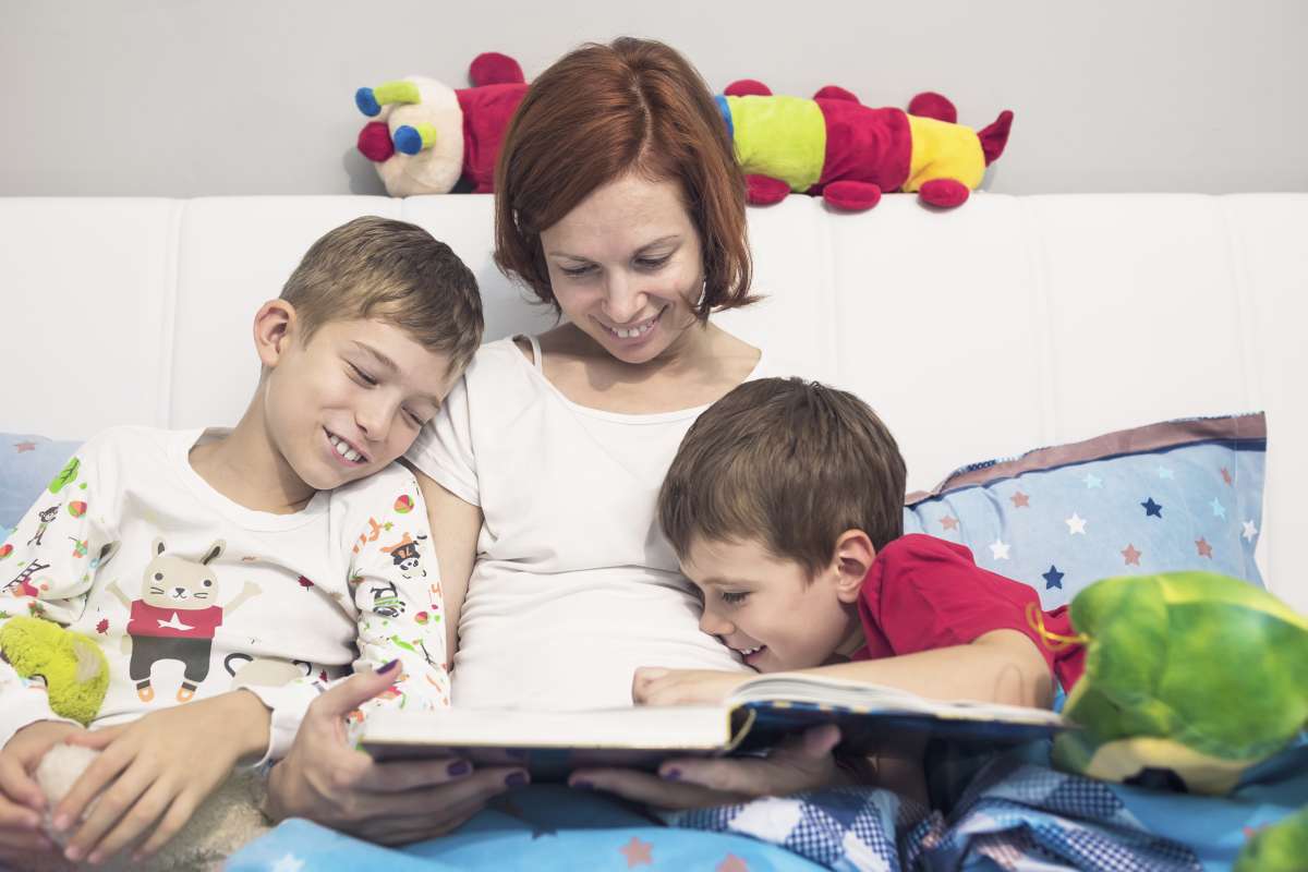 Mother reading a story to her sons at bedtime-Sharing In Children