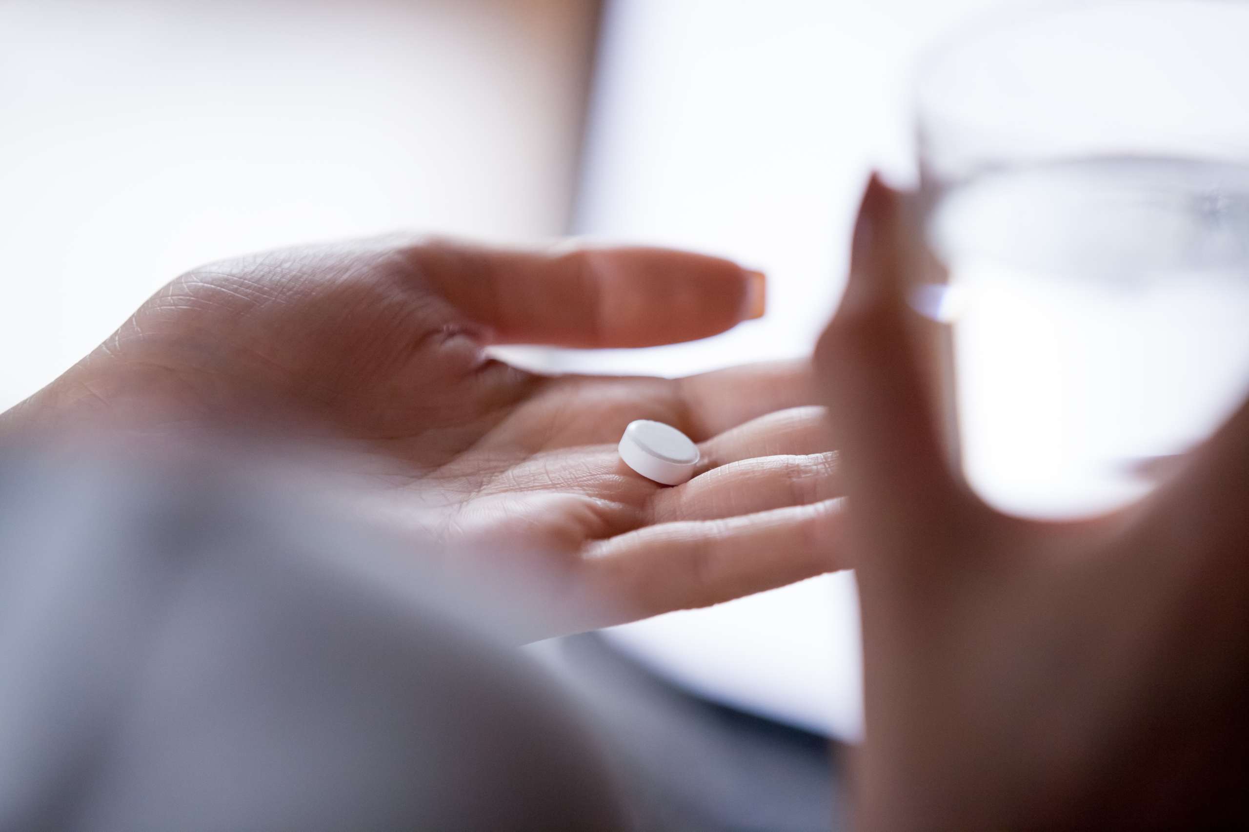 woman having a pill- Pregnant woman with pills in hand