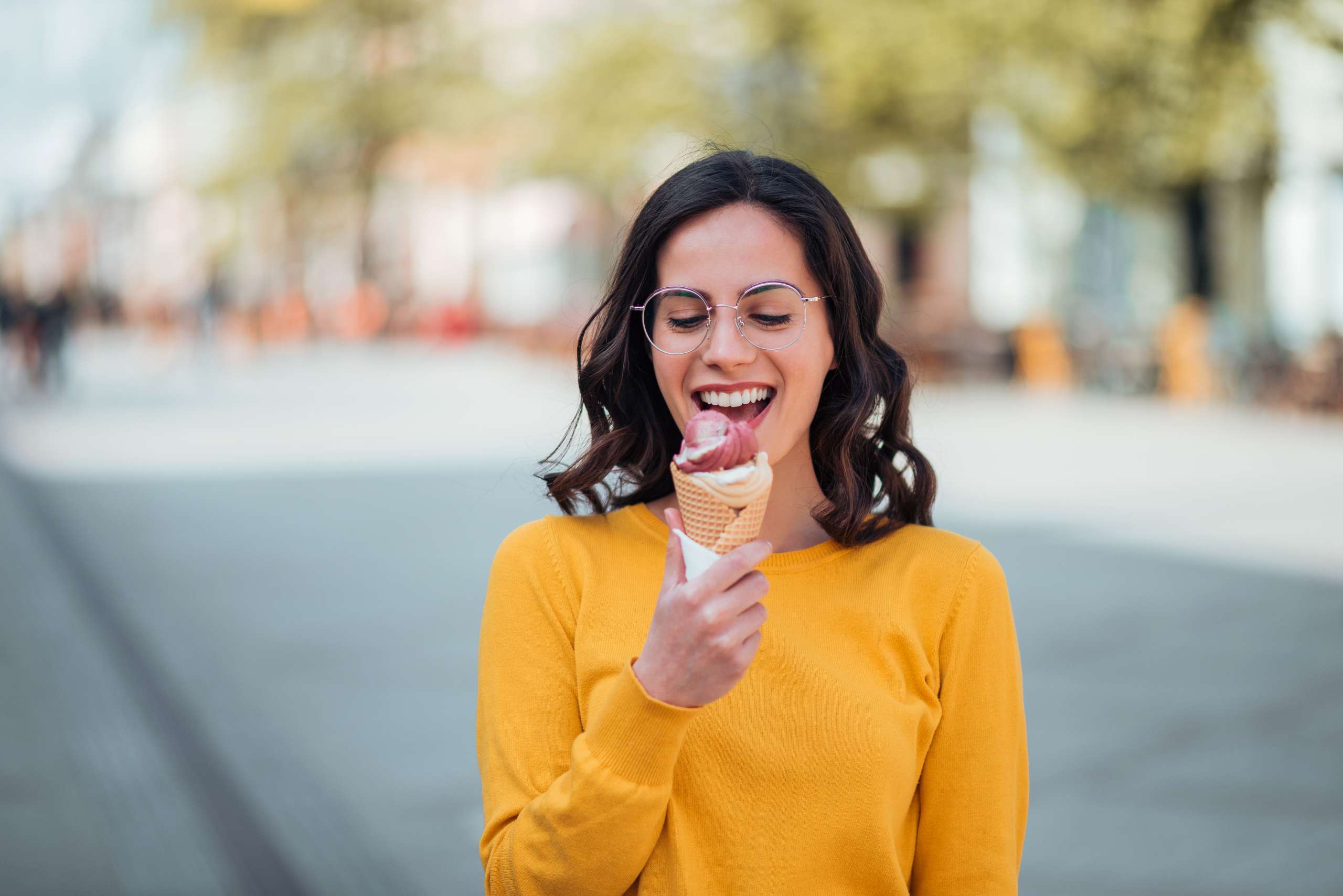 Millennial woman eating ice cream on a spring sunny day- Risks Of Consuming Too Much Caffeine