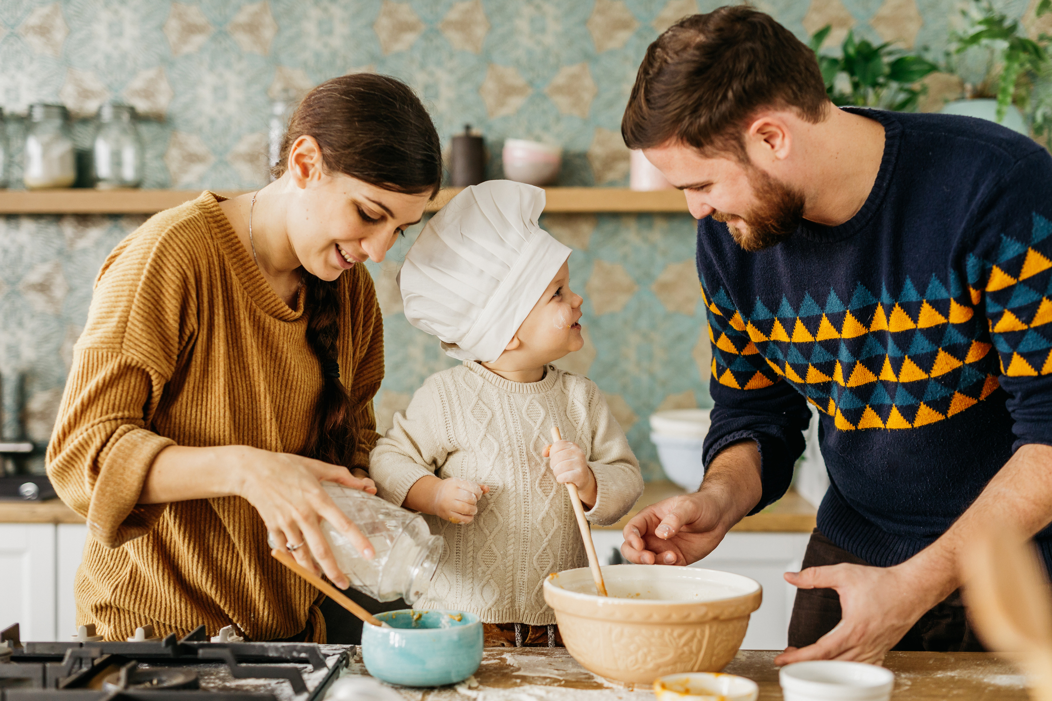 Young mother and father are cooking with their little chef-Family Traditions In Child's Identity Formation