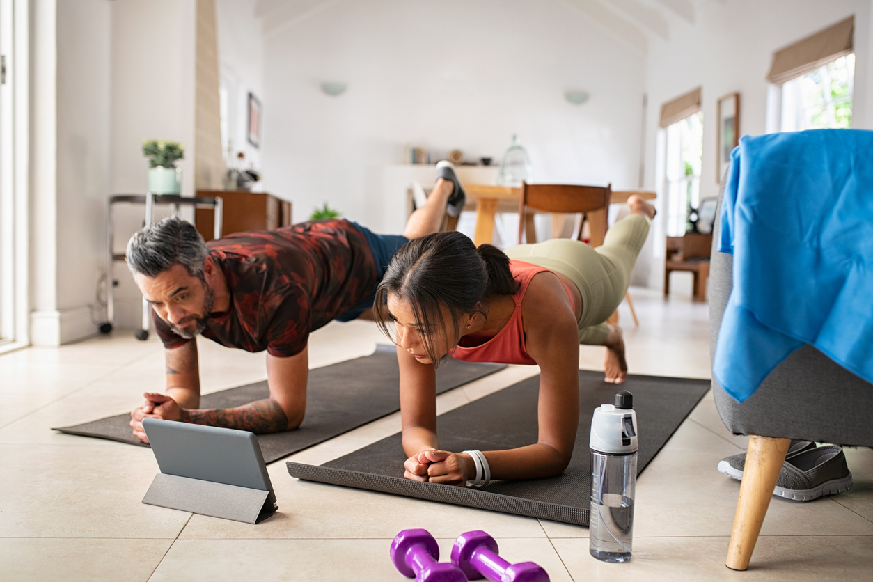 Mixed race couple practicing stretching exercise at home- Reducing Gestational Diabetes 