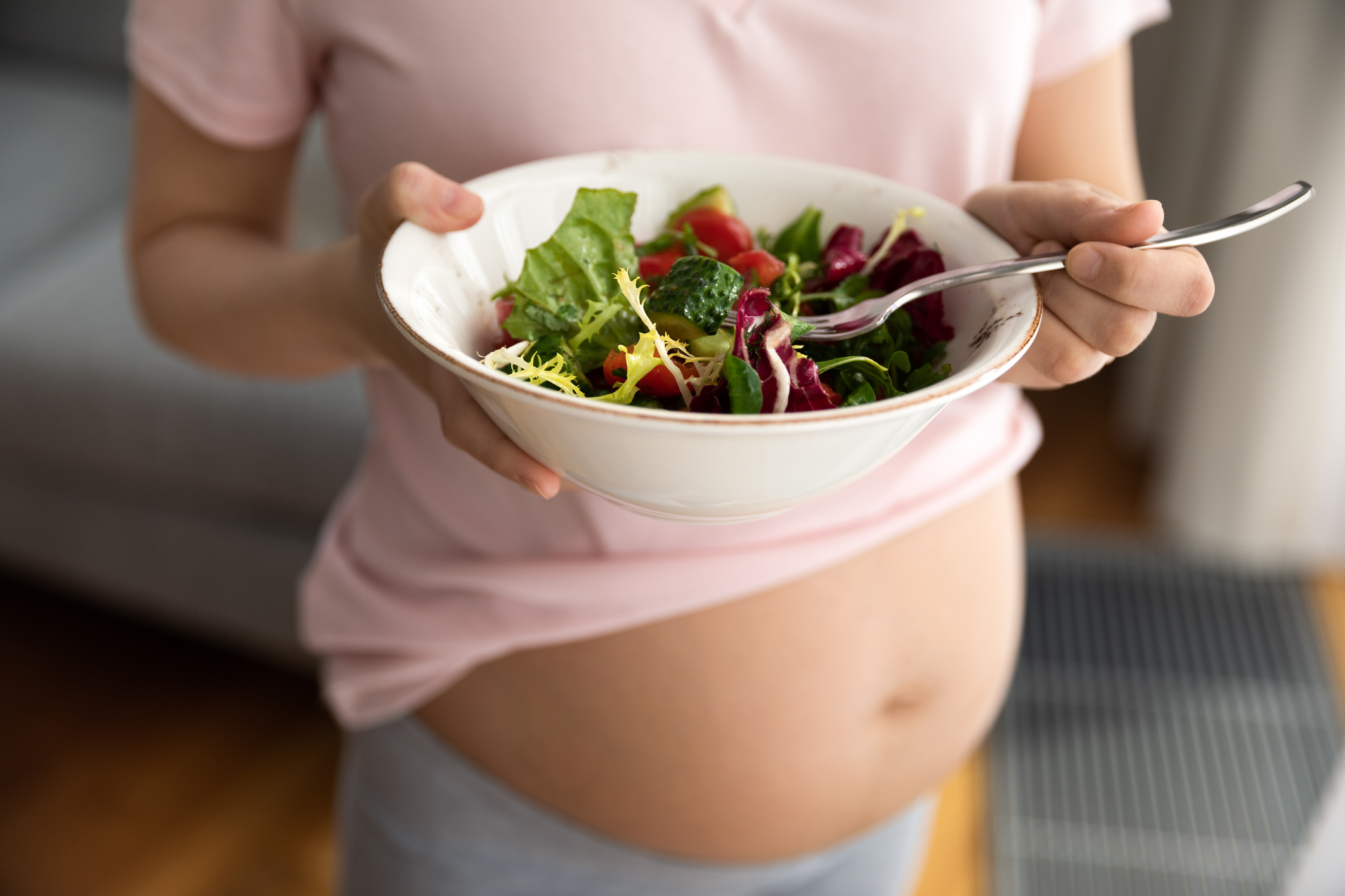 Expectant mother holding bowl with fresh vegetable salad-  Iodine In Your Diet 