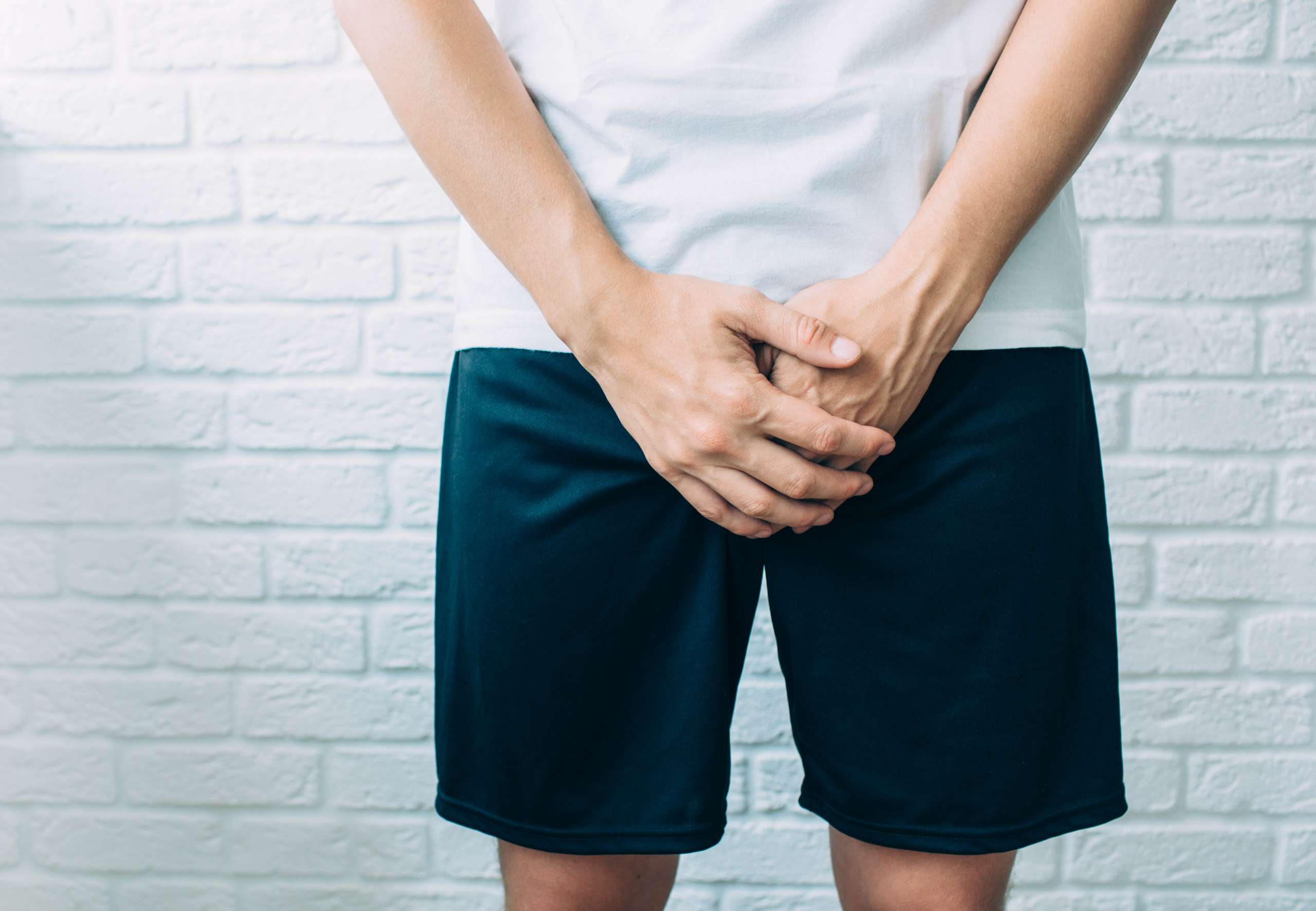 man wearing shorts holding genitals. STI- Effects Of STIs On Fertility